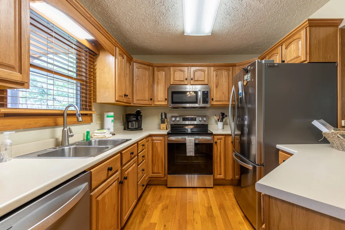 The image spotlights a well-appointed kitchen with stainless steel appliances, ample cabinetry, a spacious countertop, and sink area—ready for everything from morning coffee to elaborate home-cooked meals. The vibe is both practical and welcoming, ideal for group cooking and gathering.